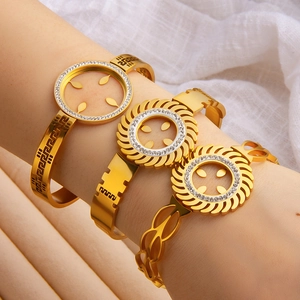 Detail of three gold-plated bangle bracelets featuring Greek meander and sunburst patterns