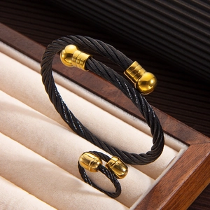 Detail of black stainless steel twisted cable bracelet and ring set in a wooden jewelry box