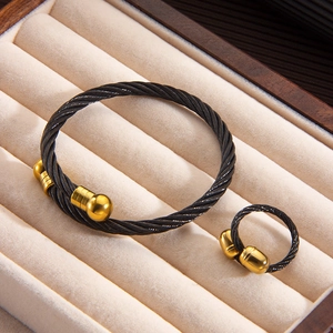 Detail of twisted black cable jewelry set with gold ball ends and grooved finish