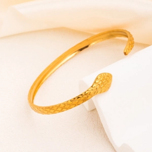 Snake-shaped open bracelet in 18k gold plated titanium steel with fine scale texture details