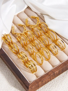 Macro shot of 18k gold-plated geometric hoop earring set in beige jewelry box