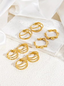 Close-up of vintage 18k gold plated geometric triple-line hoop earrings on white silk