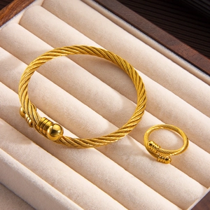 Golden steel cable jewelry set with twisted rope bangle and crossover ring