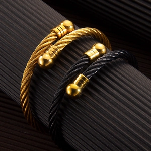Adjustable twisted steel wire bangle in gold and black with polished sphere ends