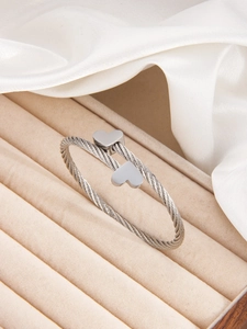 Detailed macro view of silver cable textured cuff bracelet with dual heart charms