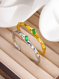 Detail of emerald inlay on hammered 18k gold plated stainless steel cuff bracelet