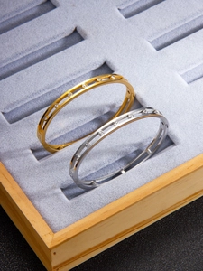 Close-up of dual-track hollow gold and silver bracelets with inlaid zircon stones