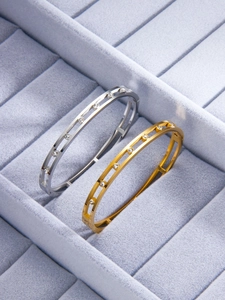 Macro view of gold and silver hollow bracelets with sparkling inlaid rhinestones