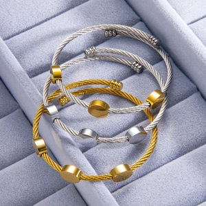 Three-piece stackable cable wire bangles in gold and silver finish on velvet