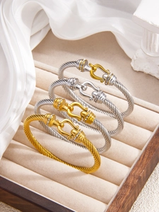 Detailed view of twisted cable bracelets with rhinestone hook clasps in gold and silver