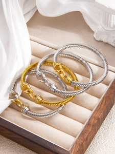 Detailed view of cable twist bracelets with sparkling zircon encrusted horseshoe clasps