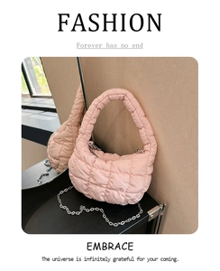 Detail of pink quilted puffy bag with silver chain strap and fashionable textures