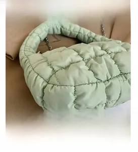 Close-up of light green quilted cloud bag featuring bubble texture and silver metal chain