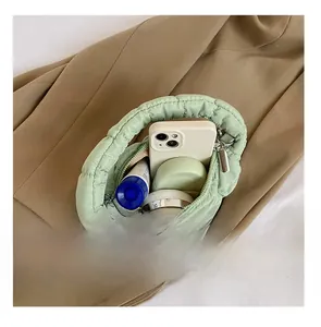 Interior view of light green quilted mini bag showing capacity for phone and cosmetics