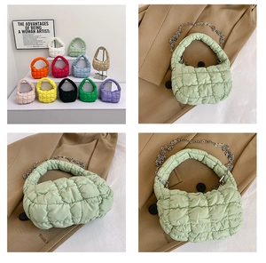 Close-up of quilted puff handbag showing mint green fabric texture and metal chain strap