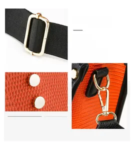 Détails des ferrures en métal doré sur le sac à main en cuir orange à texture lézard