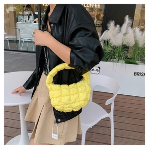 Detail of bright yellow quilted cloud handbag showing soft bubble texture and puffy handle