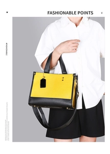 Sac à main tendance jaune à motif serpent gaufré et anses noires porté par mannequin