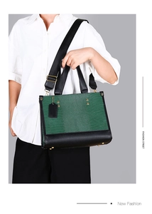 Détail du sac vert à texture lézard avec lanières en cuir noir et rivets métalliques
