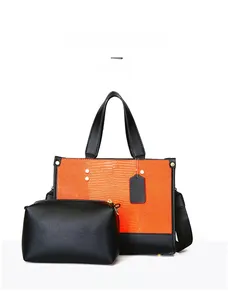 Détail du grand sac cabas à motif lézard avec pochette noire et rivets décoratifs