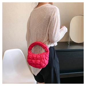 Detail of rose red quilted cloud bag with metallic chain strap and textured bubble fabric