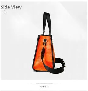 Vue latérale du grand sac orange à texture lézard avec poignées noires et détails dorés