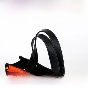 Détail du sac fourre-tout orange tressé avec poignées noires et clous dorés