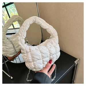 Detail of white quilted puff cloud bag featuring nylon bubble texture and silver chain strap