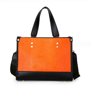 Sac fourre-tout orange à texture lézard avec détails noirs et bandoulière