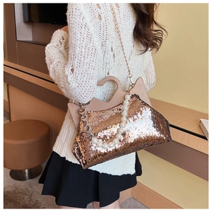 Modieuze glitter crossbodytas met parelhandvat en kattenoortjes frame getoond op model