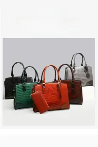 Gros plan sur les sacs à main en cuir gaufré crocodile et portefeuilles assortis