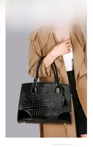 Détails du sac à main noir en cuir motif crocodile avec pieds de protection dorés