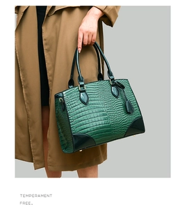 Détail du sac à main vert foncé à gaufrage crocodile avec finition brillante et pieds
