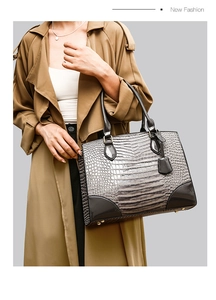 Vue macro du motif crocodile gris et des coins en cuir renforcés sur le sac à main