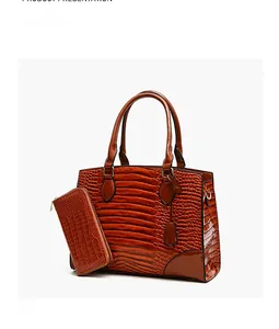 Détail du sac à main marron à texture crocodile et son portefeuille assorti