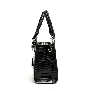 Sac à main noir brillant avec motif crocodile et détails métalliques argentés élégants