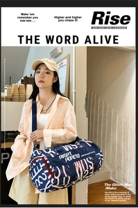 Detail view of water-resistant nylon travel bag with bold letter print and shoulder strap