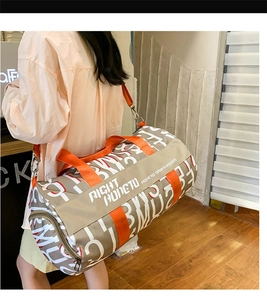 Close-up of khaki travel bag with orange straps and side zipper pocket detail