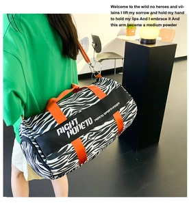 Close-up of zebra pattern duffel bag with bright orange straps and side logo detail