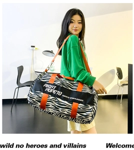 Detail of zebra print travel bag featuring vibrant orange straps and spacious interior