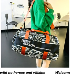 Detail of zebra print travel bag with bright orange handles and sport lifestyle text