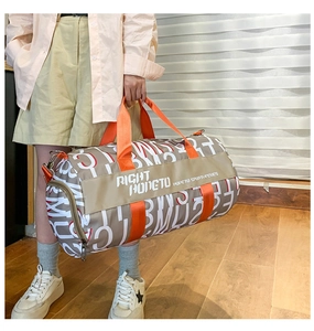 Detail of cylinder travel bag with contrast letter print and orange top handles