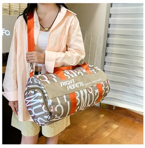 Close-up of khaki canvas travel bag with red letters and orange webbing shoulder strap