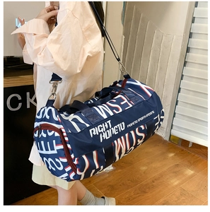 Detail of blue cylinder gym bag with bold white lettering and detachable shoulder strap