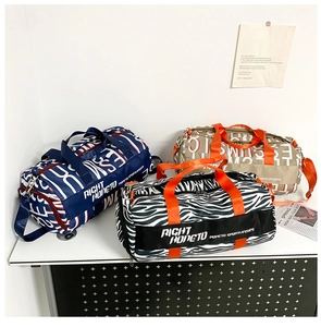 Three large travel bags in contrast prints with top handles and shoulder straps