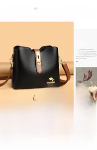 Détail du sac seau en cuir noir grainé avec logo kangourou doré et finitions brunes