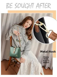 Détail du crochet en métal doré et bandoulière amovible sur un sac seau vert foncé