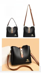 Détail du sac seau en cuir grainé noir avec anses marron et fermoir doré en métal