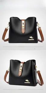 Détail du sac seau en cuir noir grainé avec bandoulière marron et logo kangourou doré