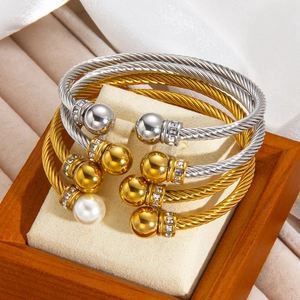 Gros plan de bracelets torsadés avec zircons et perles dans un coffret en velours